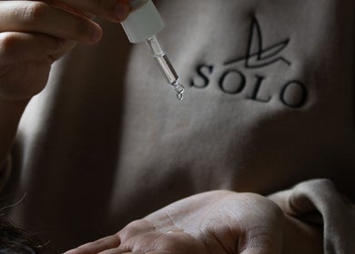 Hand applying serum at SOLO, Ajman, Ajman, AE, reflecting calm skincare expertise.