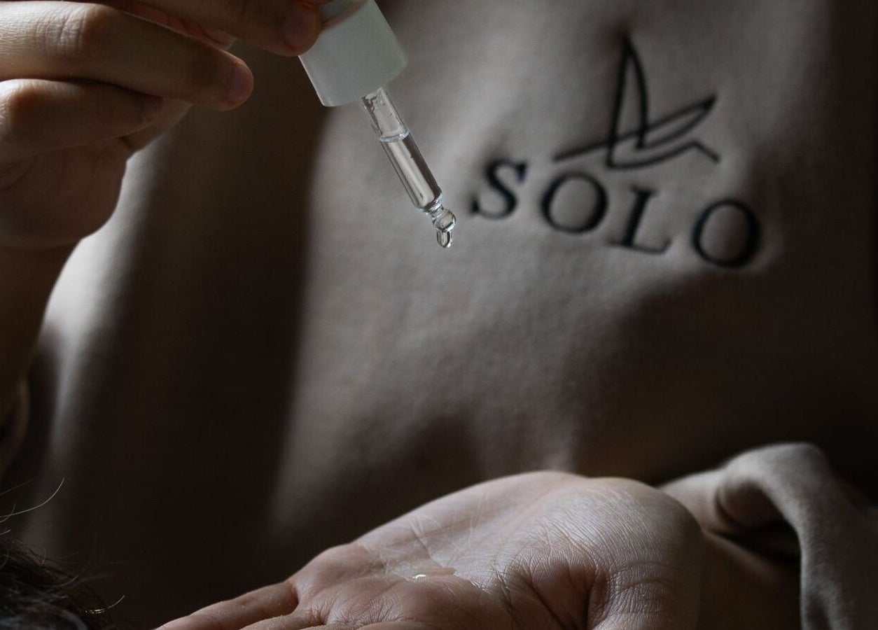 Hand applying serum at SOLO, Ajman, Ajman, AE, reflecting calm skincare expertise.