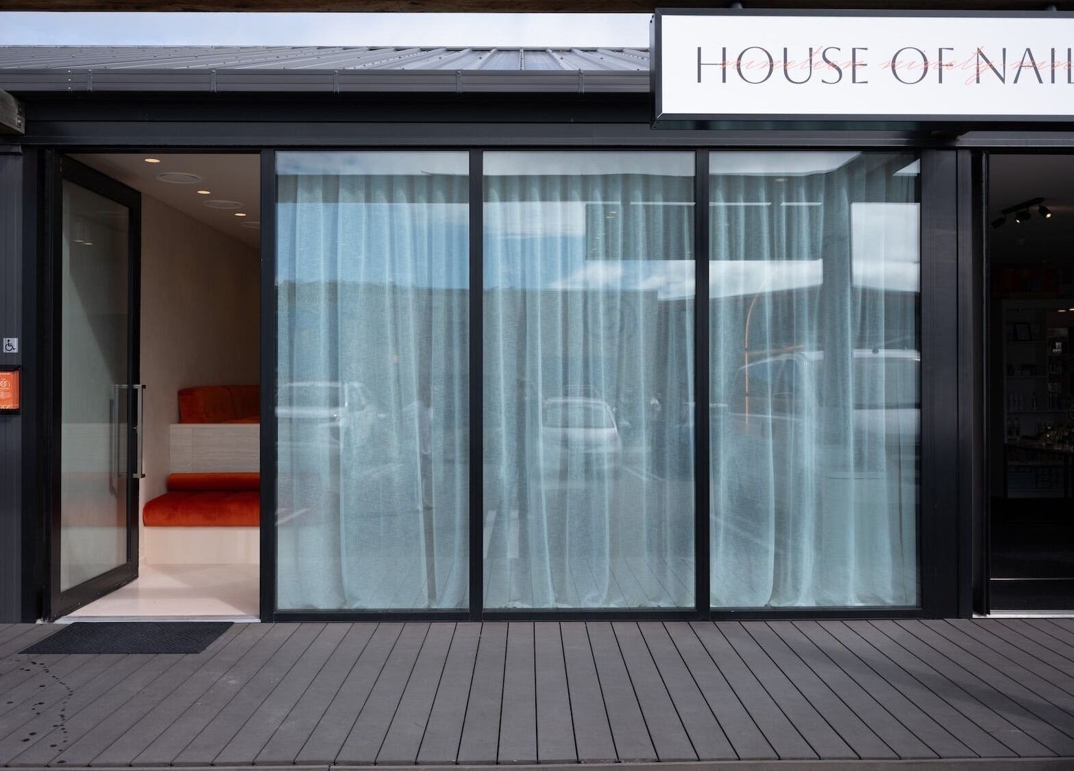 Entrance of 1999 House of Nails - Ferrymead in Christchurch, Canterbury, NZ featuring glass doors and a sign.