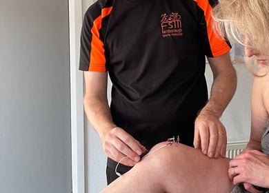 Therapist at Farnborough Sports Massage applying therapy to client's knee in Farnborough, England, GB.