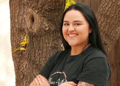 A team member at Allure Aesthetics Beauty and Waxing Salon in Gilbert, Arizona, US, smiling outdoors.