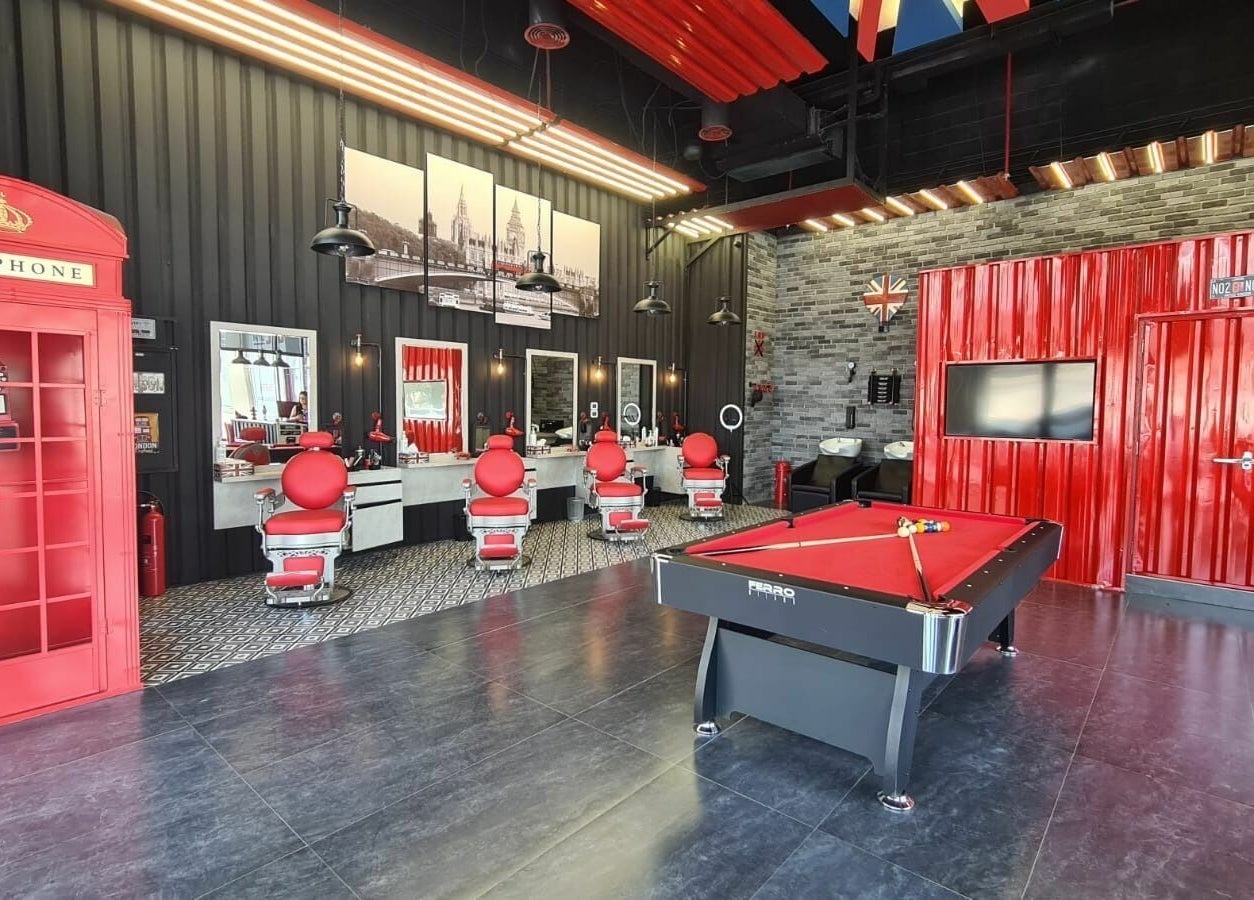 Chic interior of London Base Barbershop - Business Bay, Dubai, AE featuring red accents and modern design.