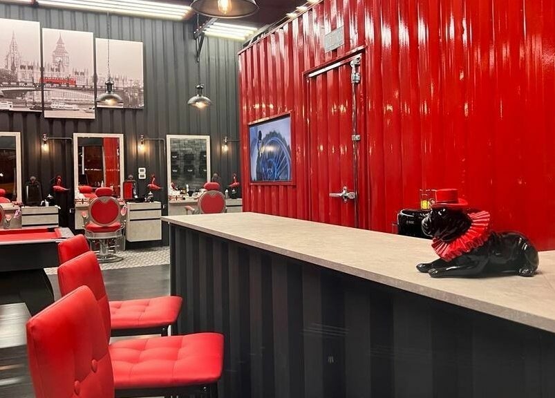 Stylish interior of London Base Barbershop - Business Bay, Dubai, AE with red accents and modern decor.