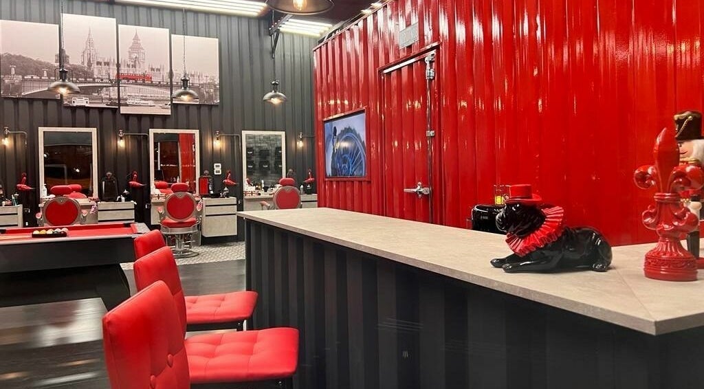 Stylish interior of London Base Barbershop - Business Bay, Dubai, AE with red accents and modern decor.