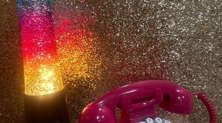 Retro pink phone and colorful lamp at Emi Nail Art, Gibraltar, GI, enhancing the venue's vibrant ambiance.