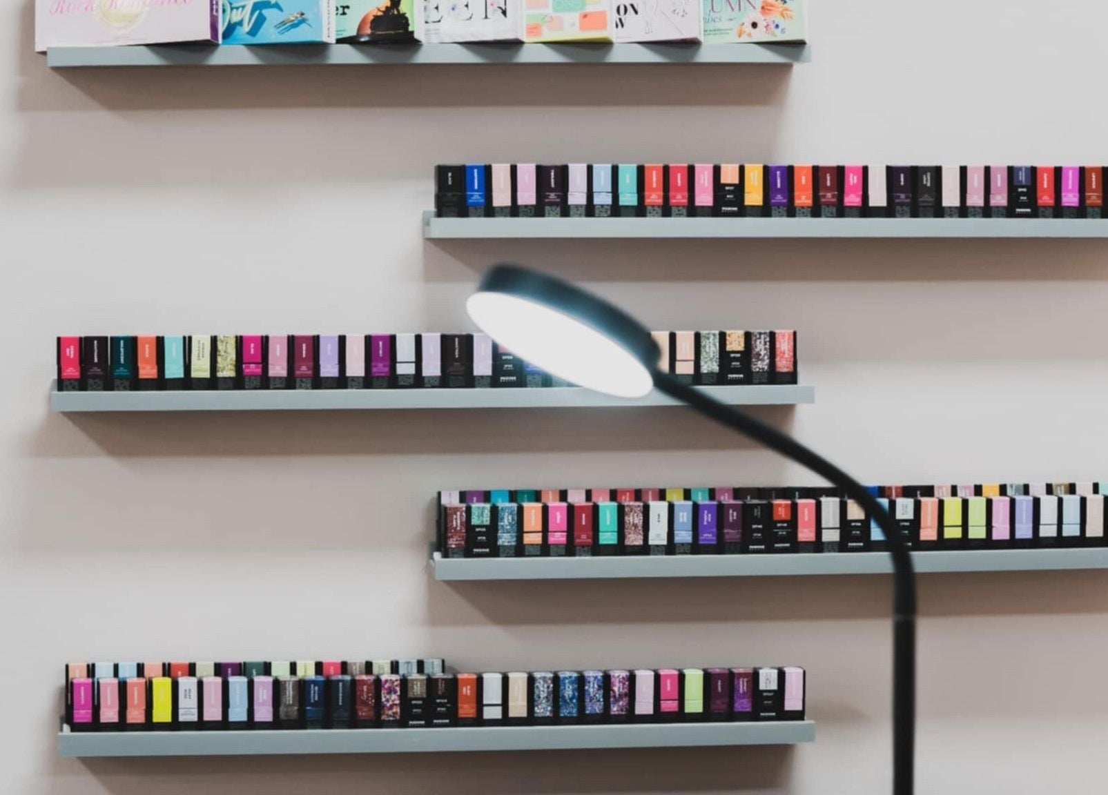 Colorful nail polish shelves at Emi Nail Art in Gibraltar, GI offering a vibrant selection.
