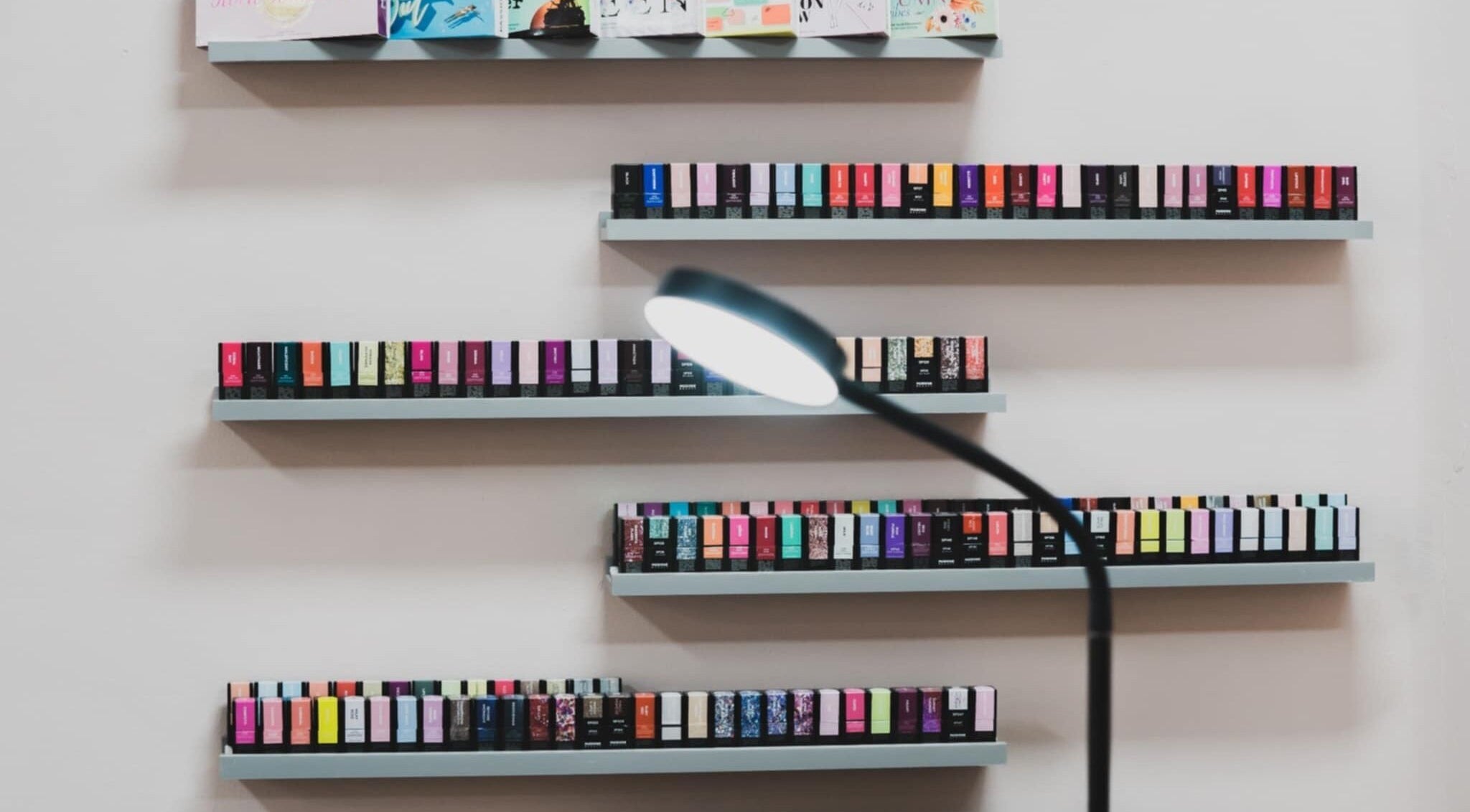 Colorful nail polish shelves at Emi Nail Art in Gibraltar, GI offering a vibrant selection.