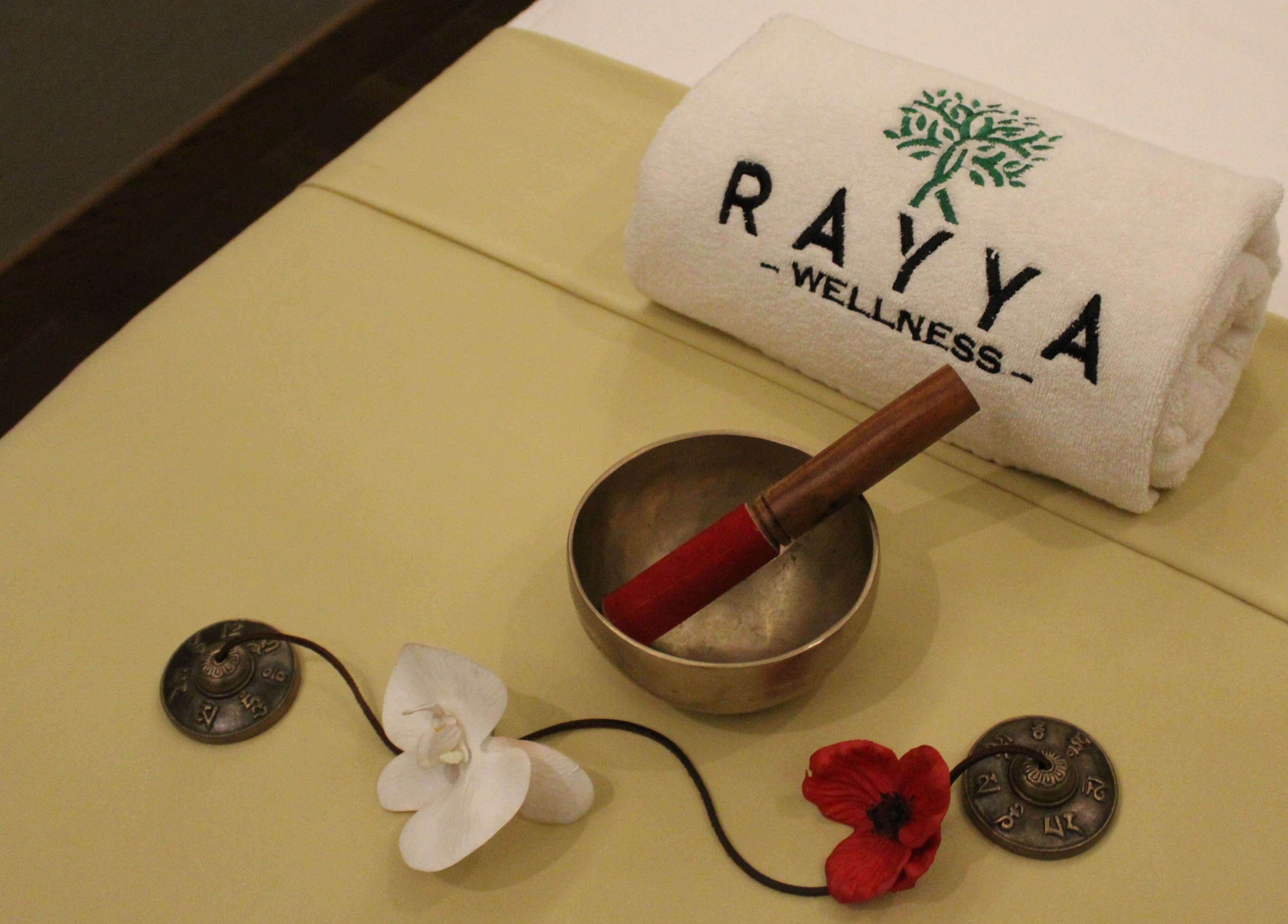 Tranquil setup at Rayya Wellness, the First Collection | Business Bay, Dubai, Dubai, AE with towel, bowl, and flowers.