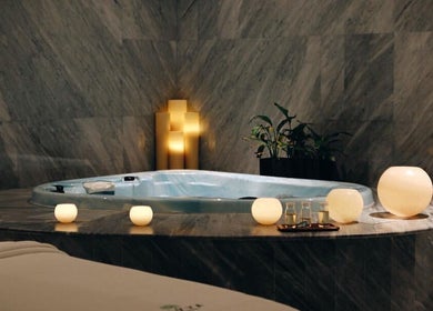 Luxurious spa setting at Rayya Wellness, Sky Bay Hotel, Dubai, AE with candles by the jacuzzi.
