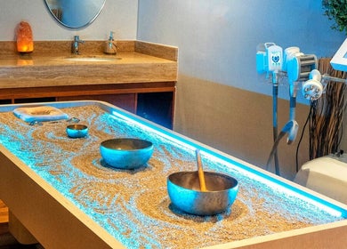Relaxing sand therapy setup at Rayya Wellness, Sky Bay Hotel, Dubai, AE with glowing lights and bowls.