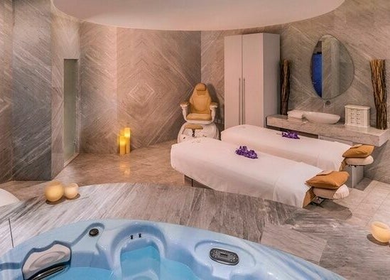 Relaxing spa suite at Rayya Wellness, The Retreat Palm Dubai Spa, Dubai, AE with massage tables and Jacuzzi.