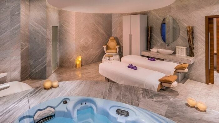 Relaxing spa suite at Rayya Wellness, The Retreat Palm Dubai Spa, Dubai, AE with massage tables and Jacuzzi.