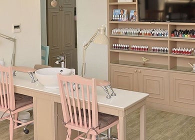 Nail salon station at Plush Beauty Spa, Abu Dhabi, AE, showcasing chic decor and a variety of polish colors.