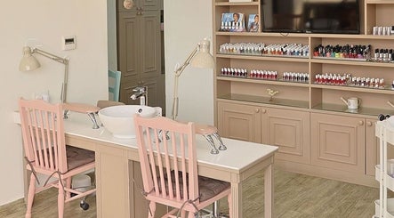 Nail salon station at Plush Beauty Spa, Abu Dhabi, AE, showcasing chic decor and a variety of polish colors.