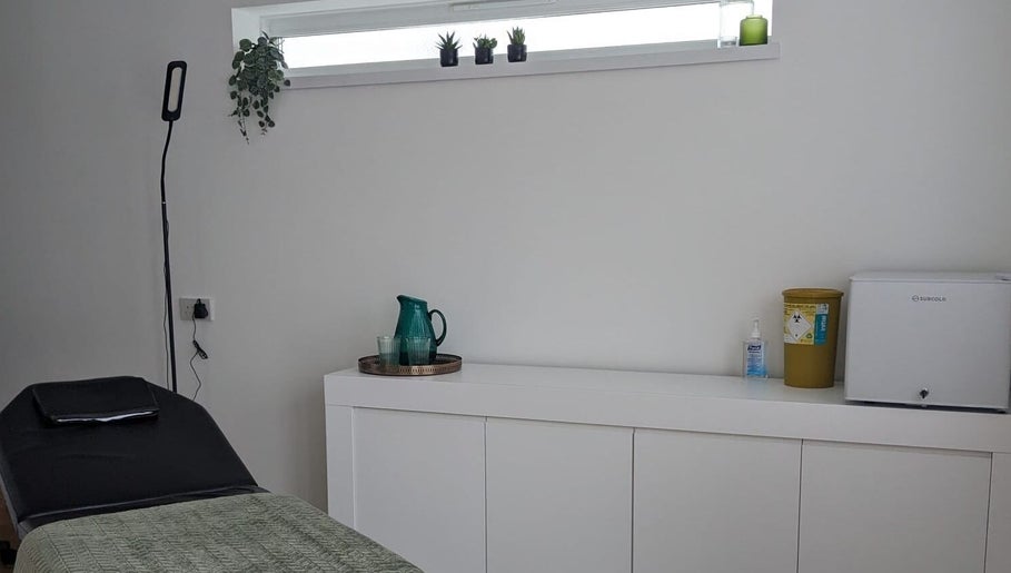 Calm treatment room at SALO Aesthetics in Plymouth, England, GB, featuring a bed and decor.