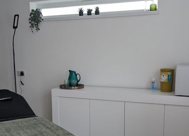 Calm treatment room at SALO Aesthetics in Plymouth, England, GB, featuring a bed and decor.