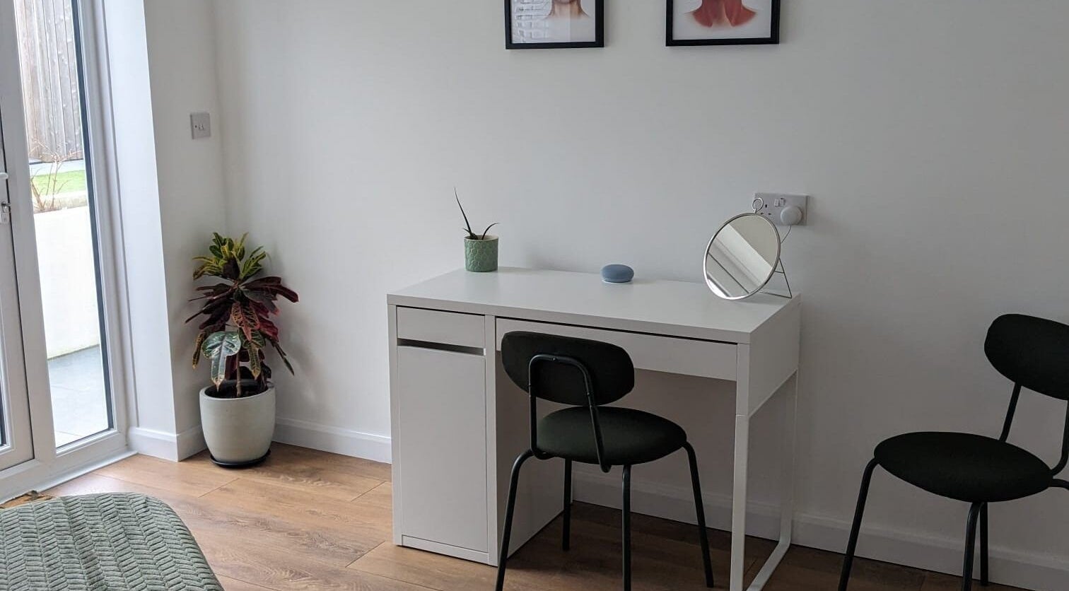 Cozy beauty station at SALO Aesthetics, Plymouth, England. White desk, mirror, plants enhance the space.