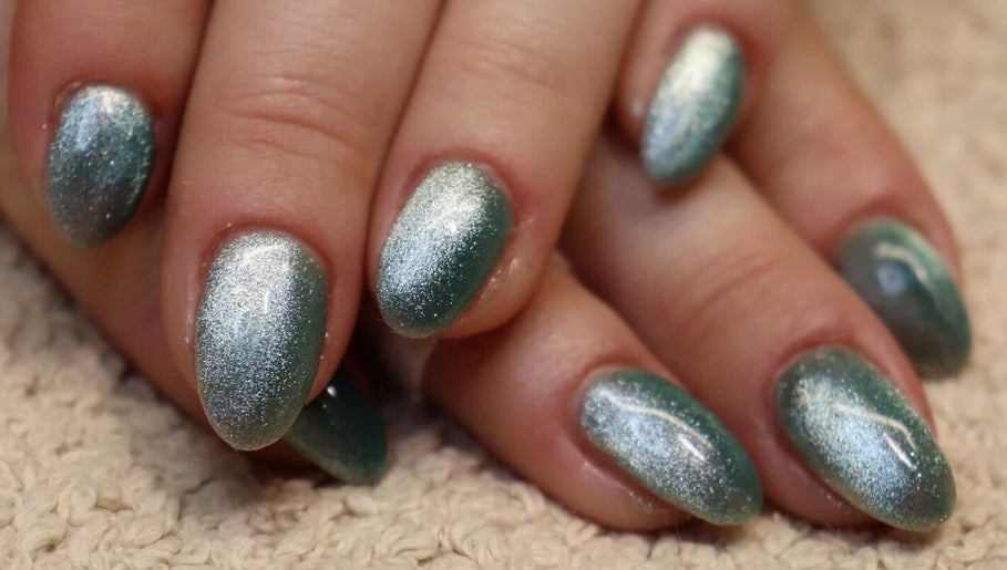 Acrylic nails with green glitter polish at Bare Beauty, Strensall, England, GB.