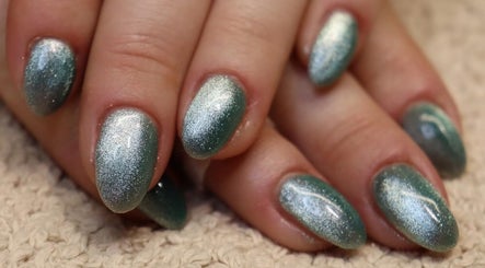 Acrylic nails with green glitter polish at Bare Beauty, Strensall, England, GB.