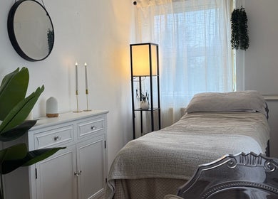 Tranquil spa room at Bare Beauty, Strensall, England featuring cozy bed, ambient lighting, and elegant decor.
