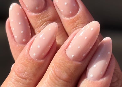 Polished nails with white dots at Bare Beauty, Strensall, England, GB. Perfect manicure for elegance.
