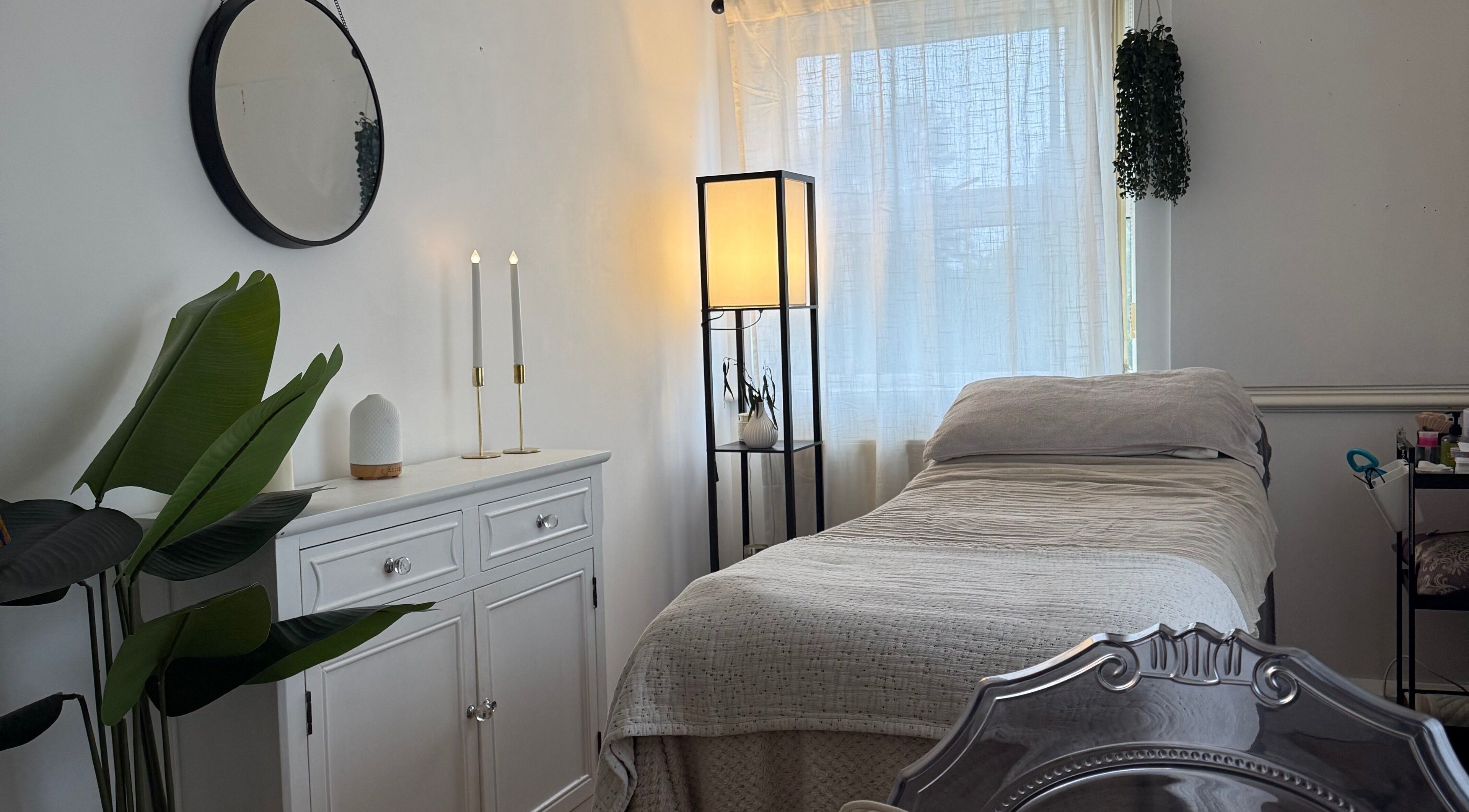 Cozy treatment room at Bare Beauty, Strensall, England, GB, with a relaxing bed and elegant decor.