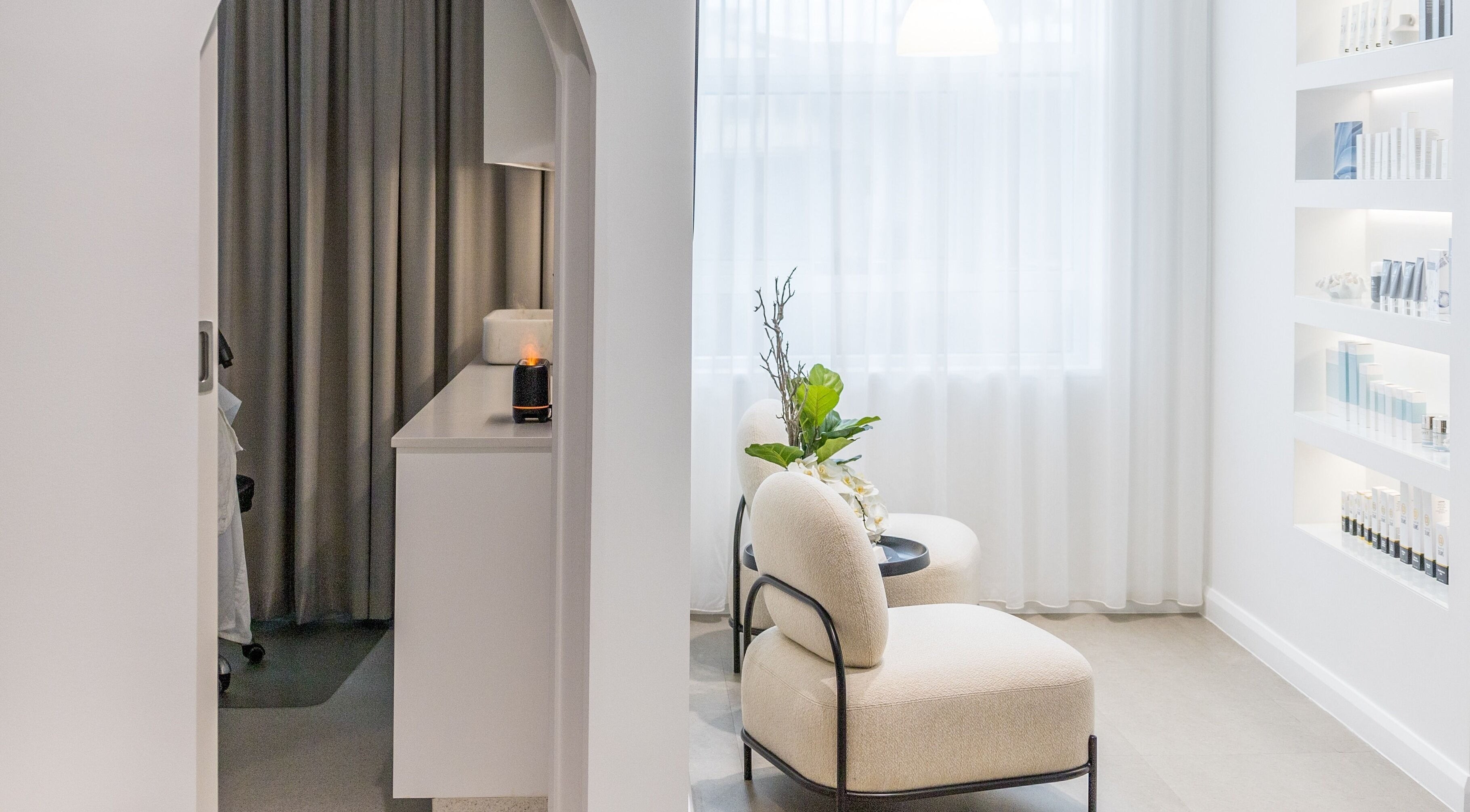 Relaxing lounge area at Simply Luminous Skin, Wentworth Point, New South Wales, AU with elegant chairs and soft lighting.