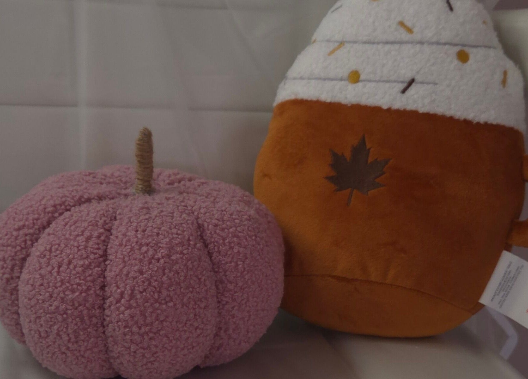 Plush pumpkin and coffee mug decor at Shardilly Nails, Hebburn, England, GB enhance a cozy ambiance.