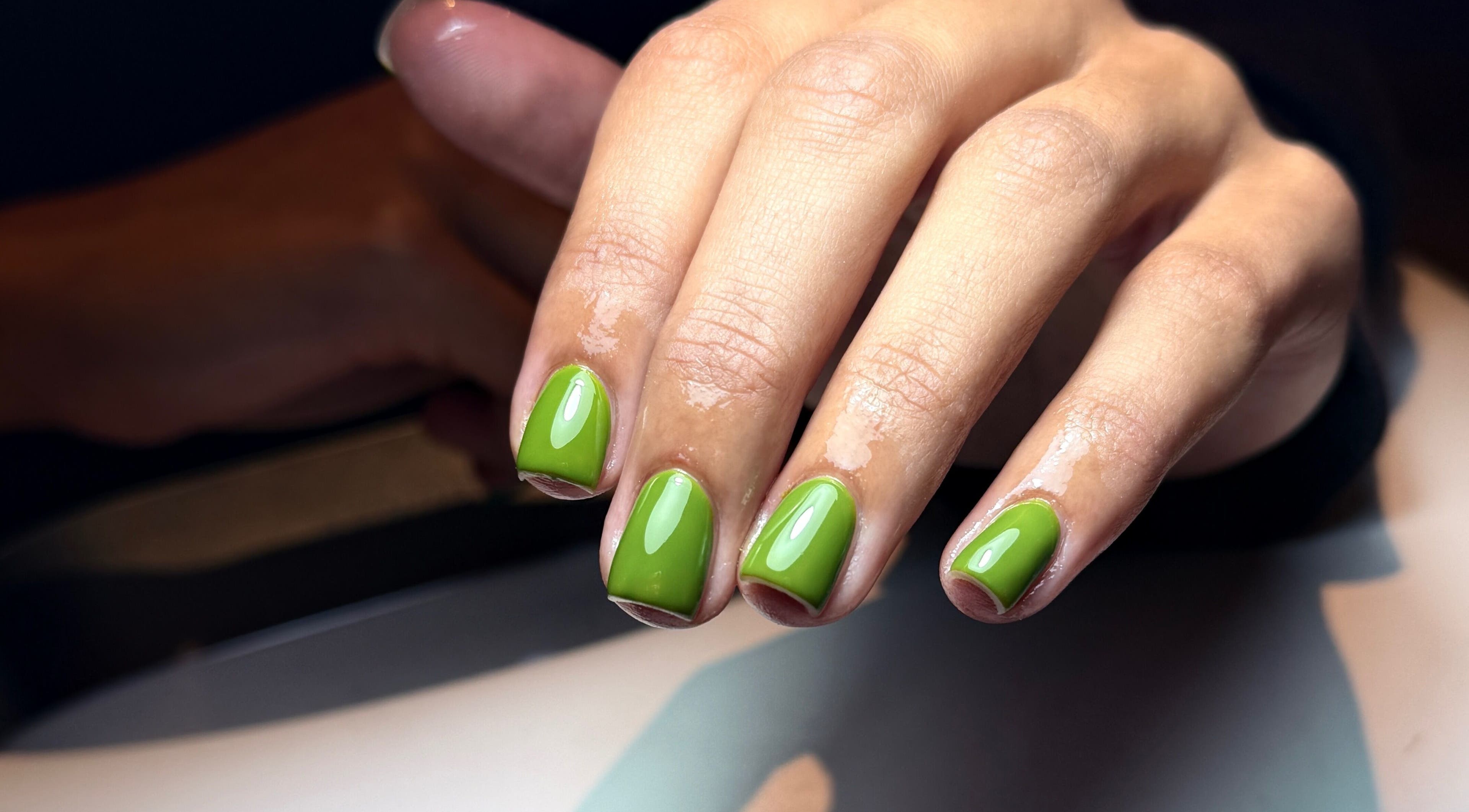Bright green manicure at Glo Nailz, Earby, England, GB, showing glossy nails in vibrant lime color.