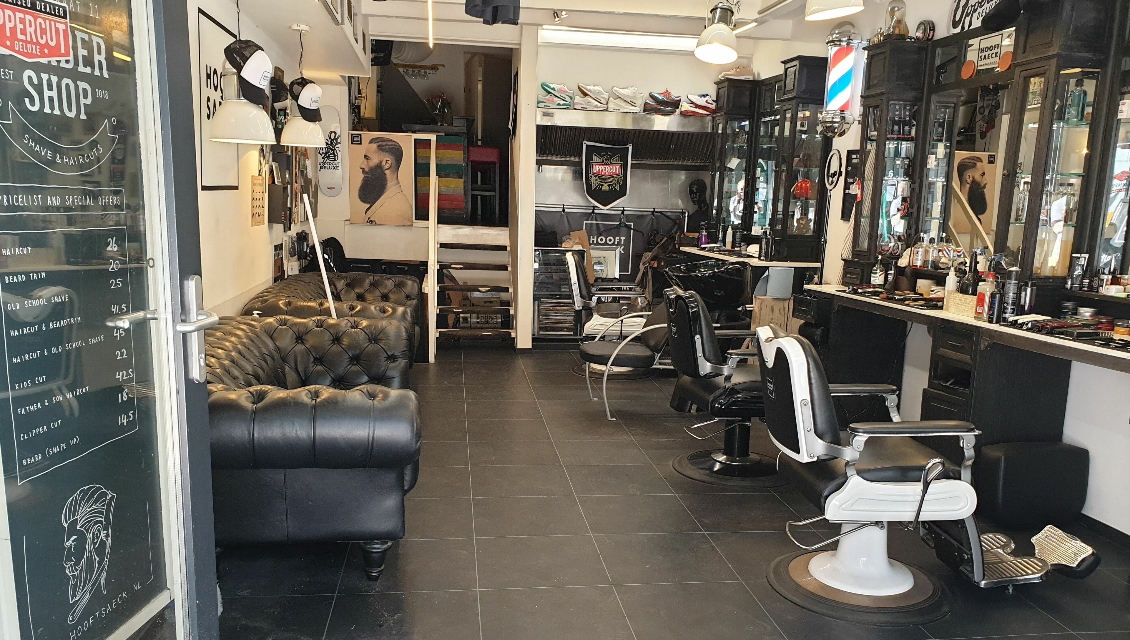 Interieur van Hooftsaeck Barbershop in Harderwijk, Gelderland, NL met stoelen, spiegels en bank.