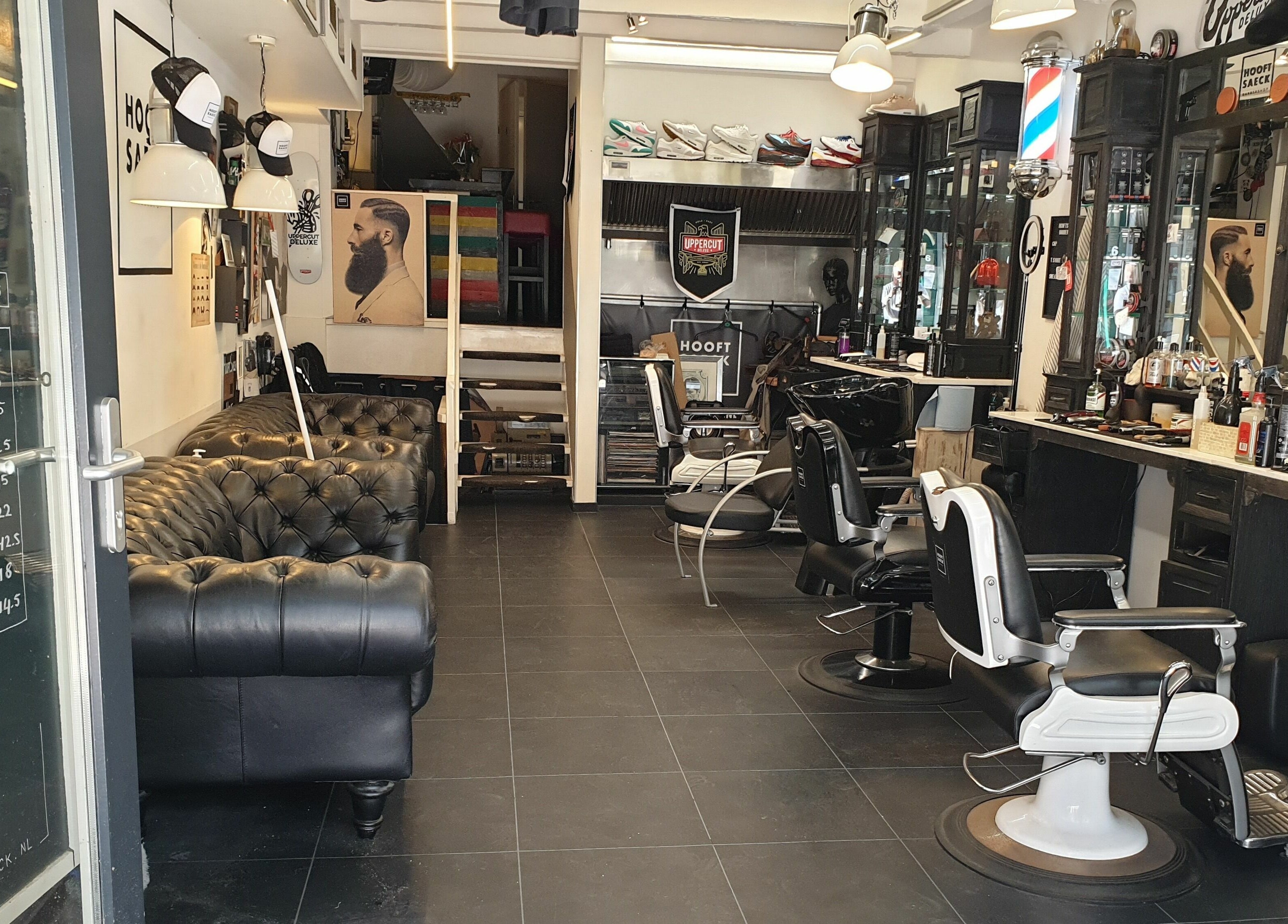 Interieur van Hooftsaeck Barbershop in Harderwijk, Gelderland, NL met stoelen, spiegels en bank.