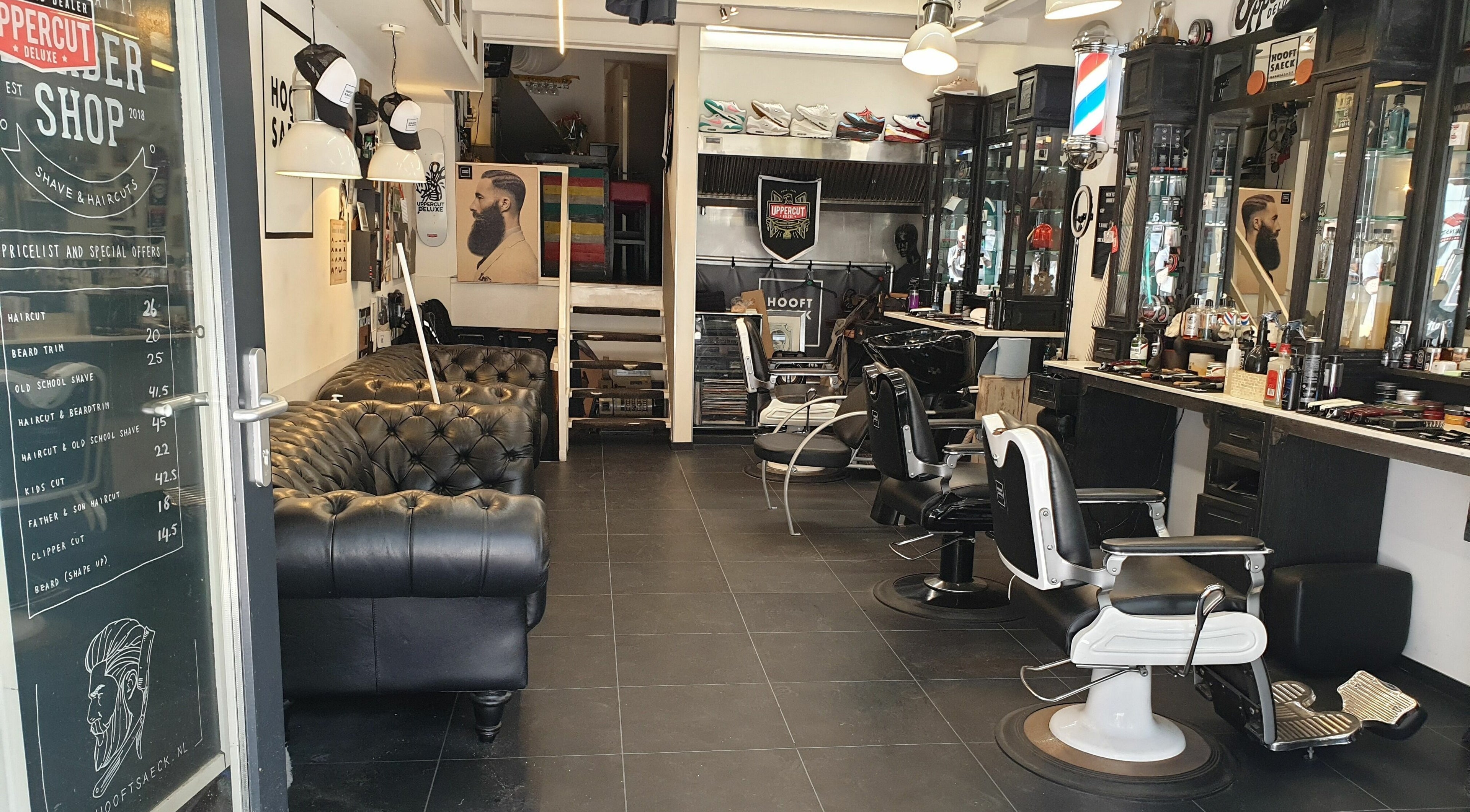 Interieur van Hooftsaeck Barbershop in Harderwijk, Gelderland, NL met stoelen, spiegels en bank.