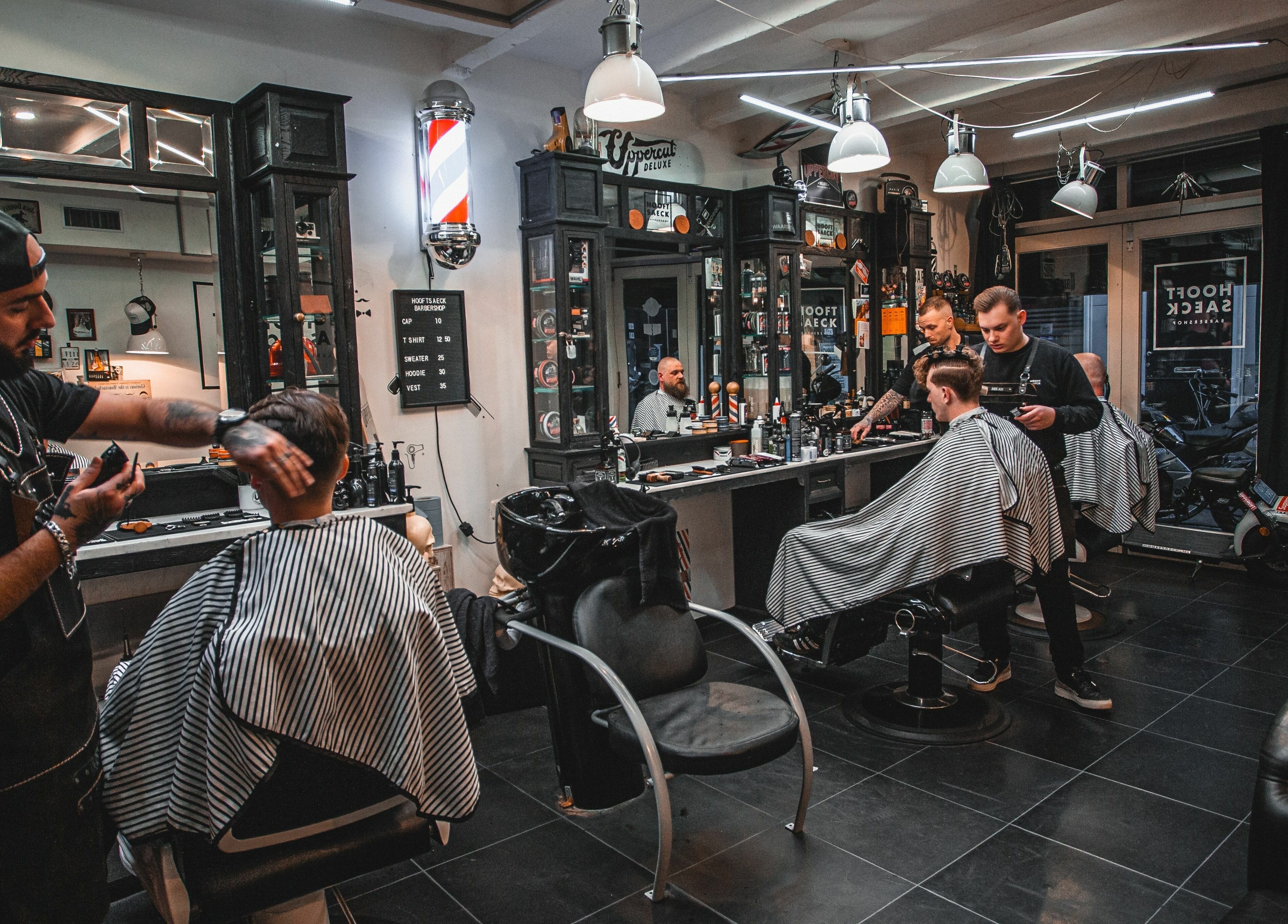 Stijlvolle inrichting van Hooftsaeck Barbershop, Harderwijk, Gelderland, NL met kappers aan het werk.