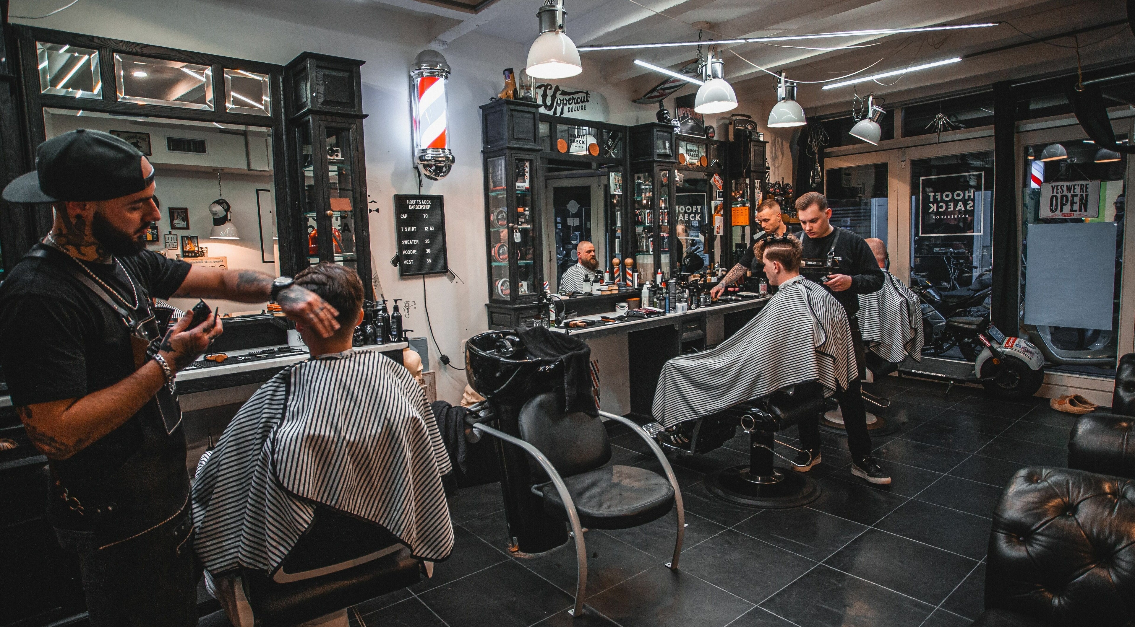 Stijlvolle inrichting van Hooftsaeck Barbershop, Harderwijk, Gelderland, NL met kappers aan het werk.