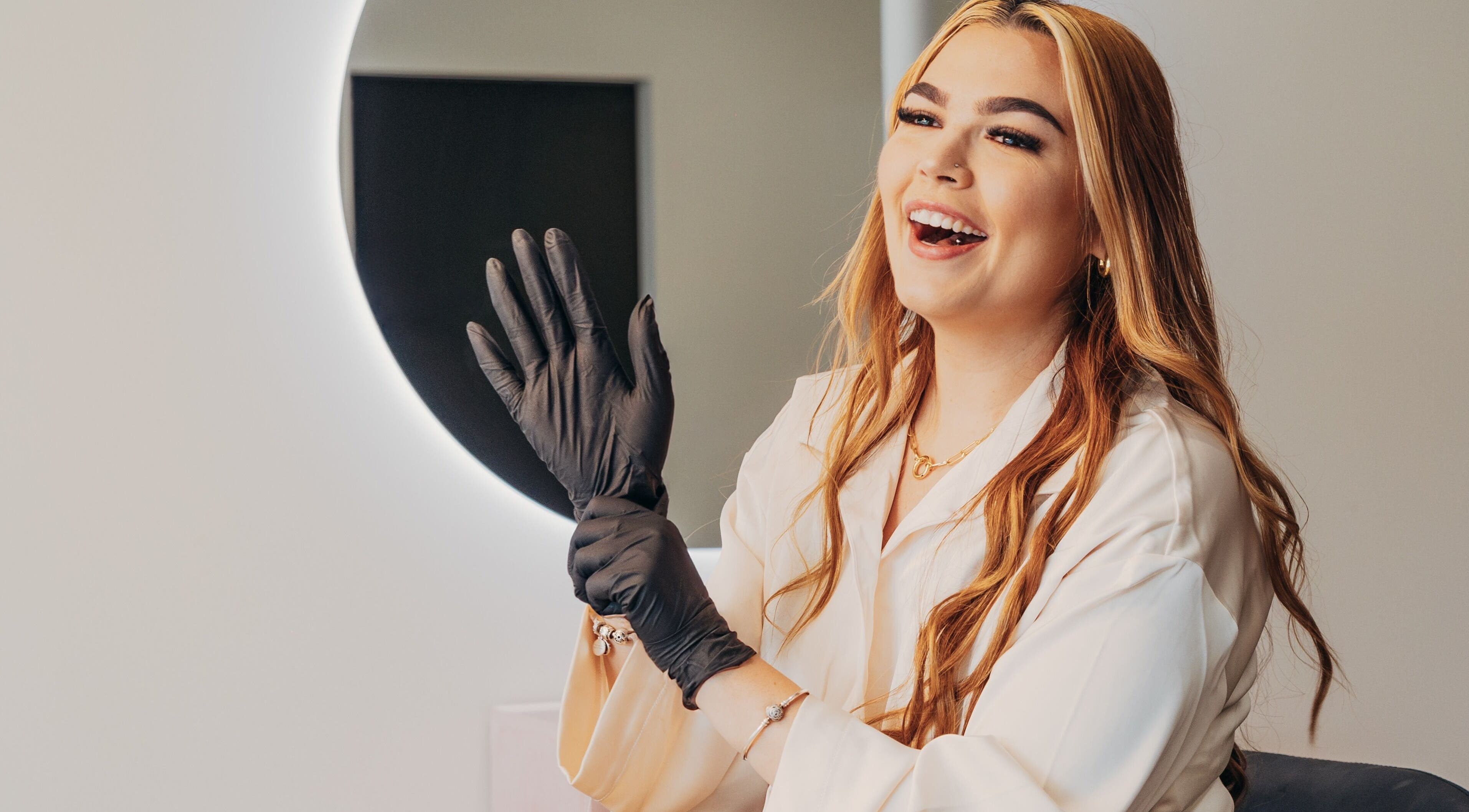 Lux Aesthetix professional preparing in Mooloolaba, Queensland, AU with gloves on for beauty service.