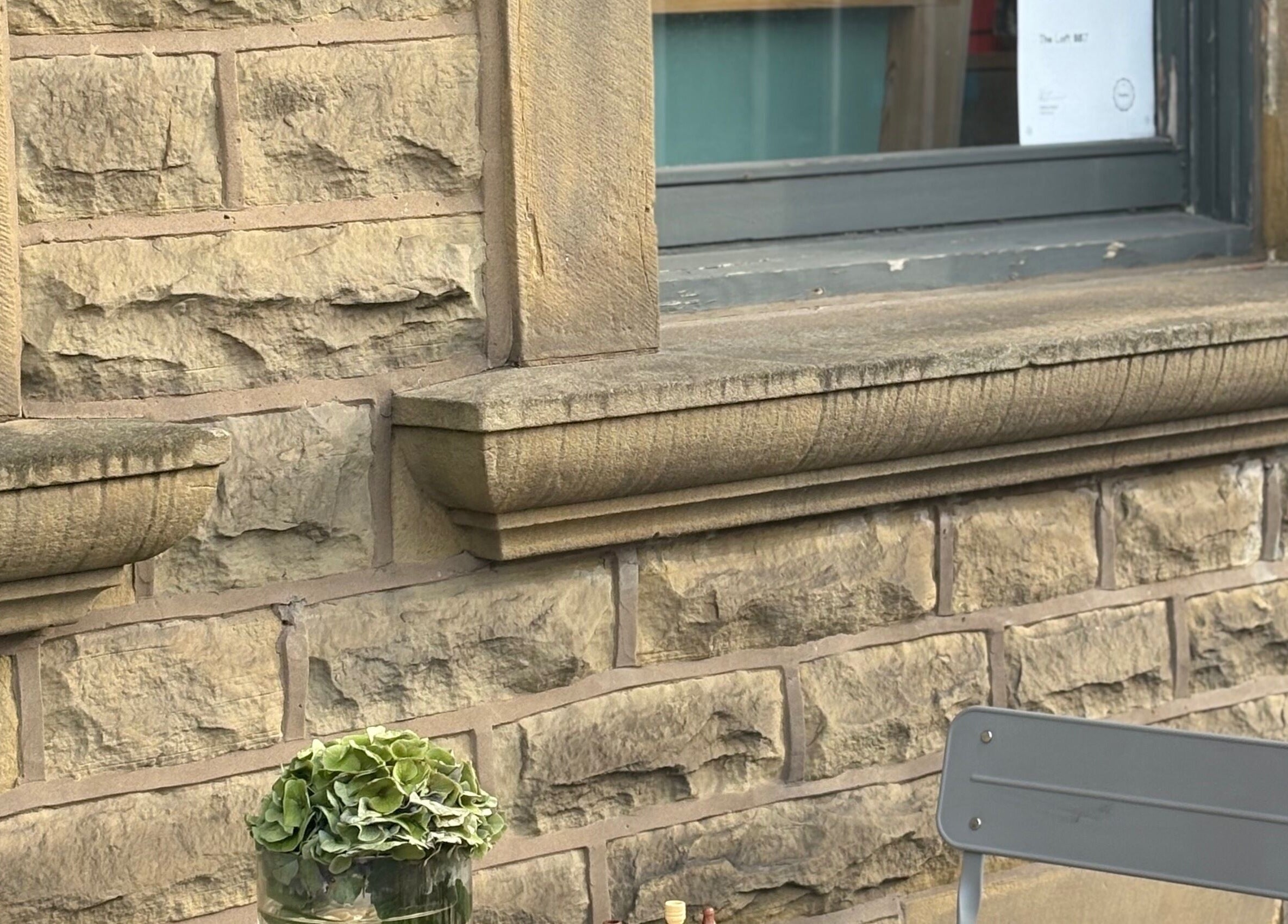 Outdoor seating at The Loft BB7, Clitheroe, England, GB, featuring vintage stone walls and lush greenery.