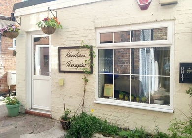 Front view of Kanchani Therapies in Leek, England with a welcoming entrance and vibrant hanging plants.