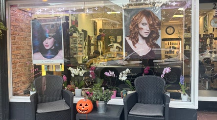 Exterior of Bita Hair Studio in Southampton, England, GB adorned with stylish hair posters and floral decor.