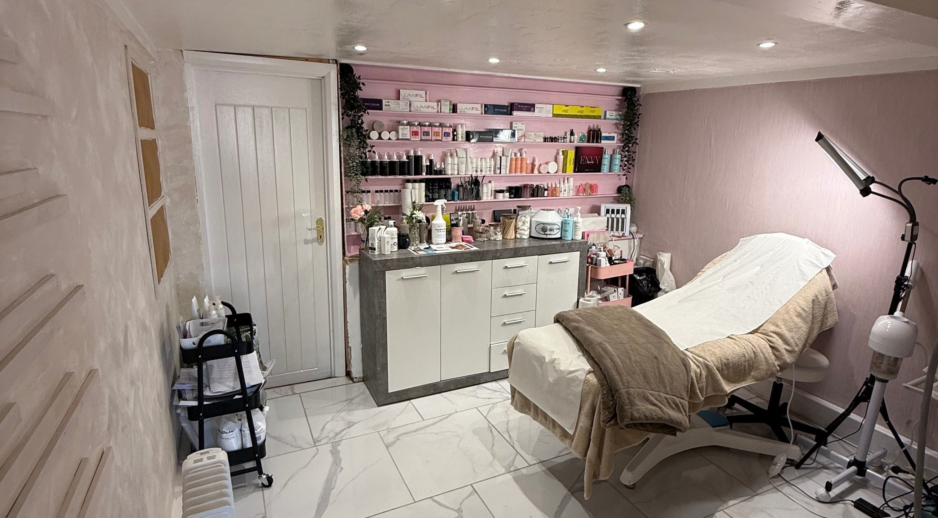Relaxing treatment room at Naked Beauty and Aesthetics, Church Gresley, England, GB, with cozy setup and products.
