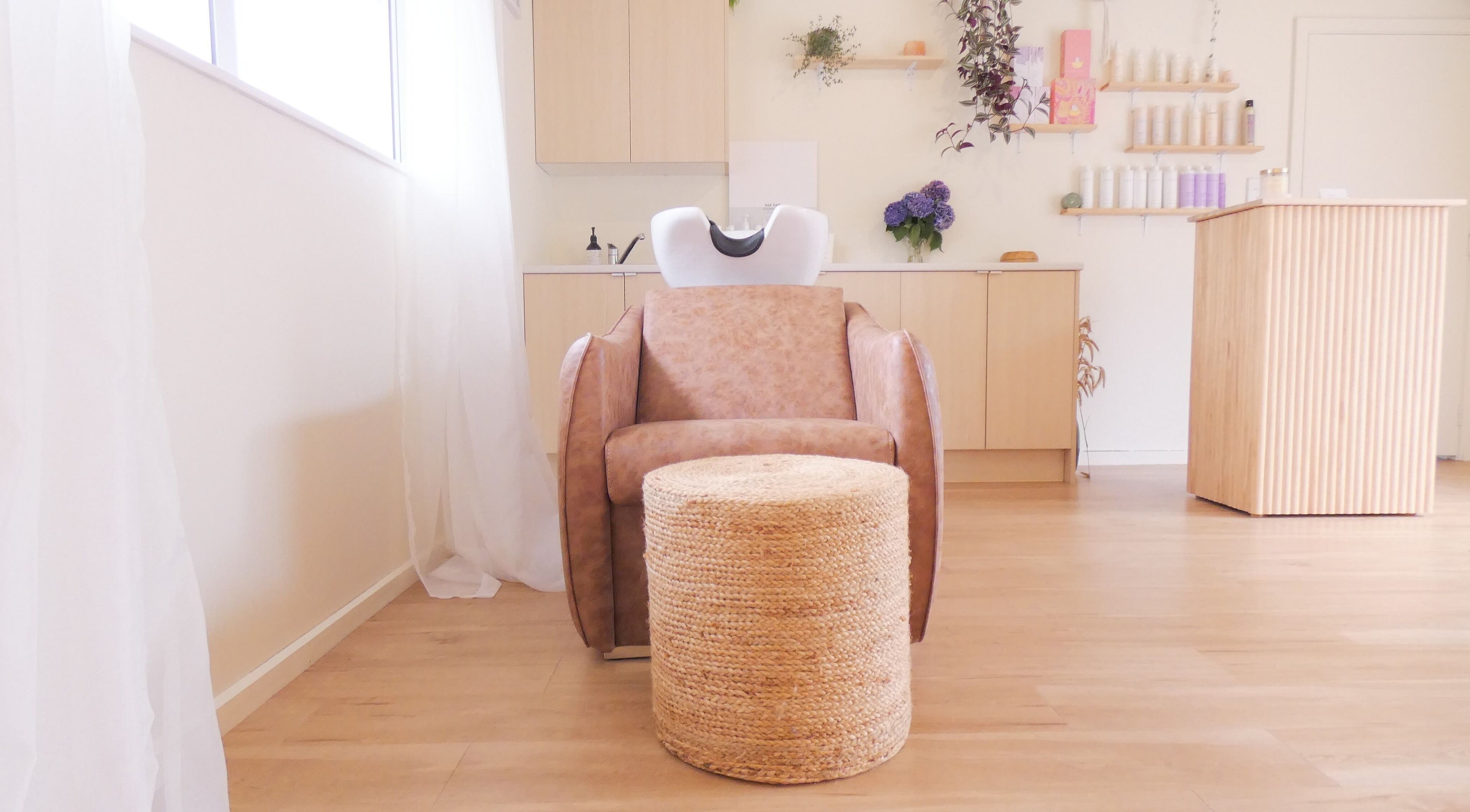 Relaxing washstation at Gwen the Salon in Ohoka, Canterbury, NZ, featuring cozy seating and stylish decor.