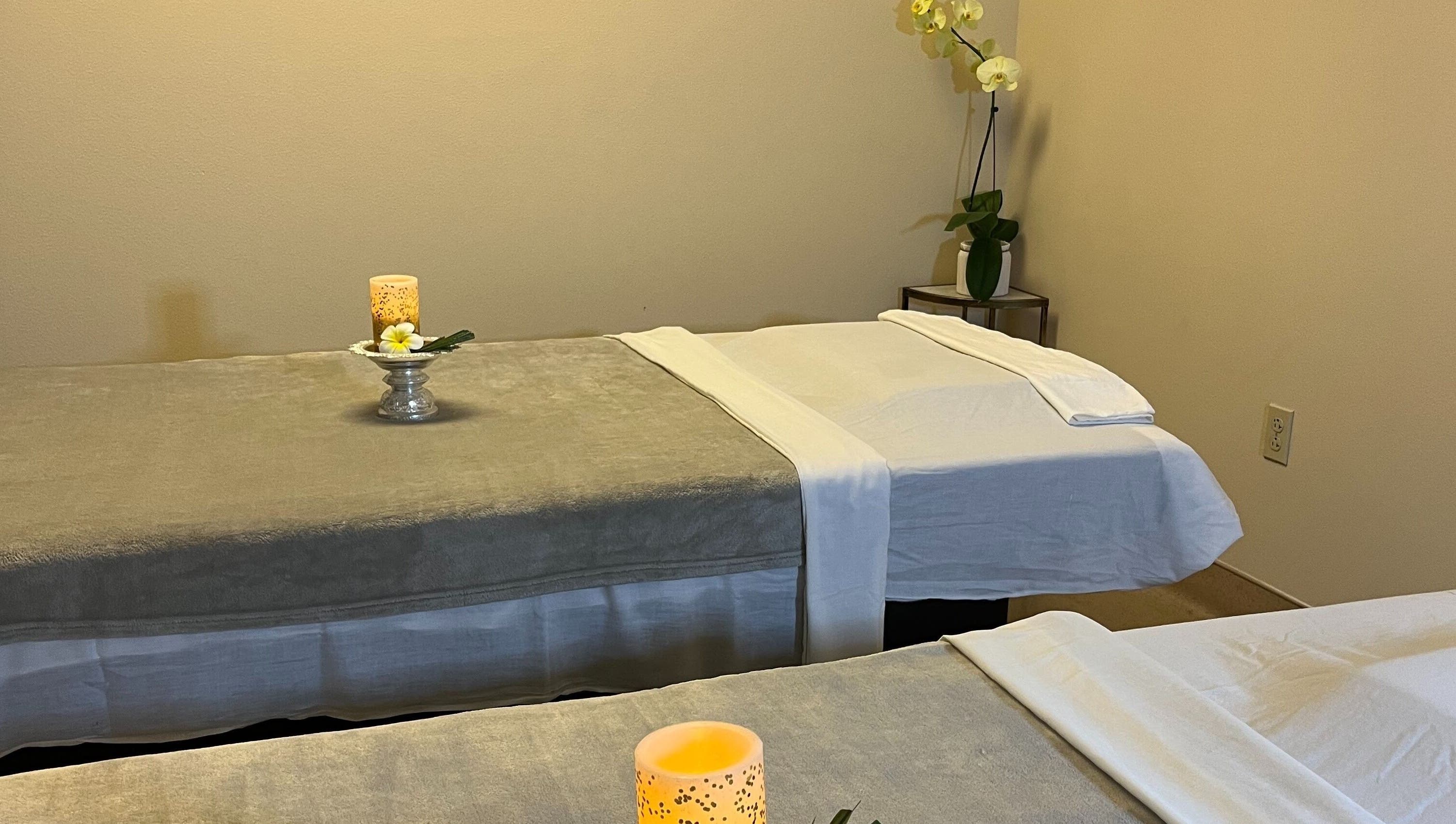 Calming massage room at Bua Thai Massage, Las Vegas, Nevada with two beds and decorative candles.