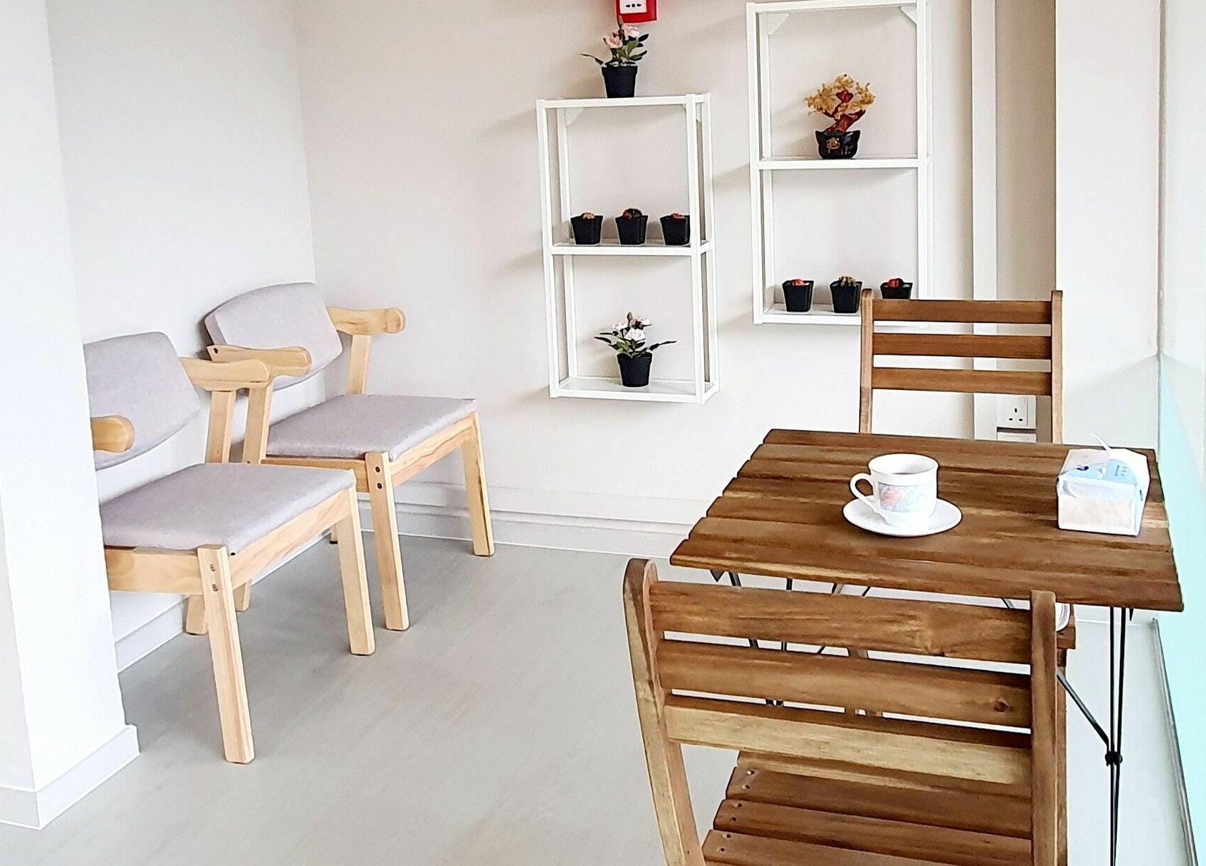 Cozy waiting area at Gro Wellness Asia 佫洛养生轩 (Farrer Park), Singapore with wood chairs and table.