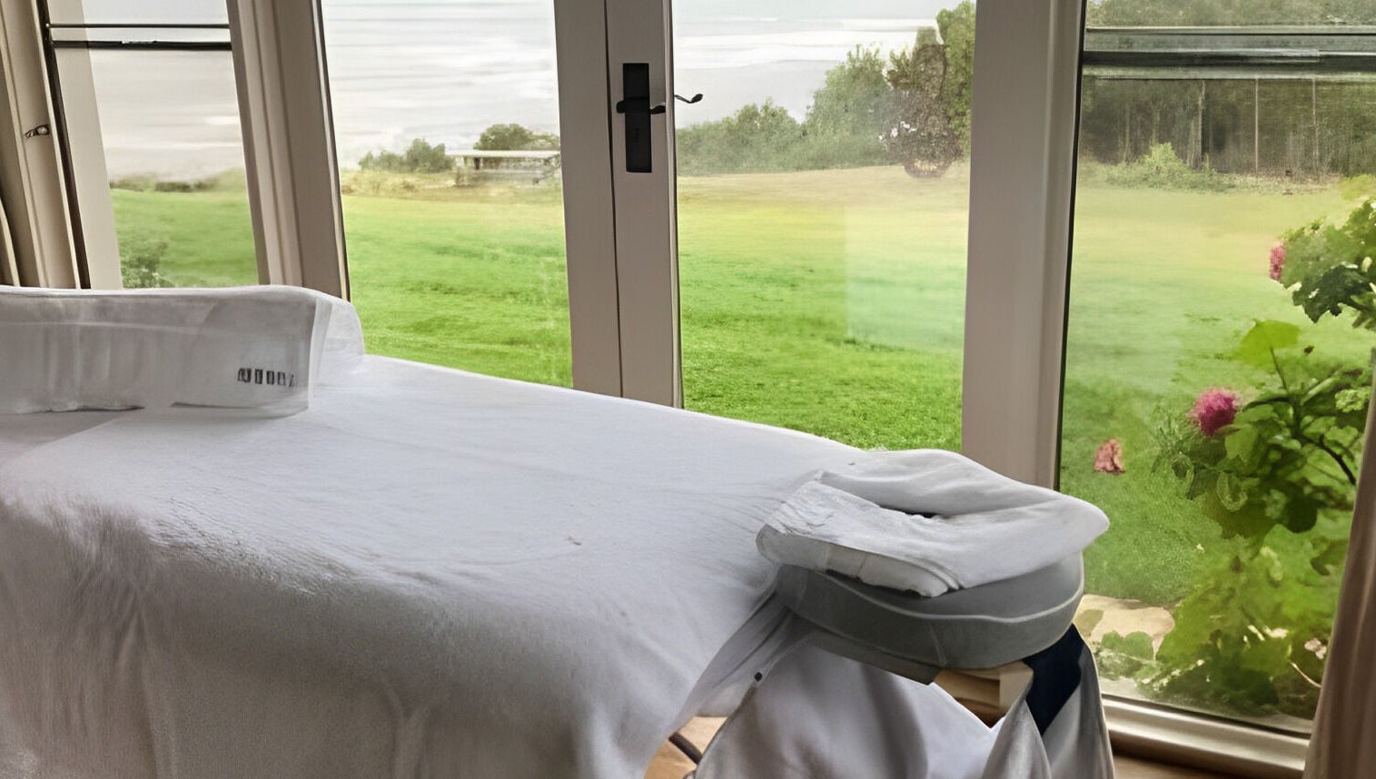 Massage table overlooking lush greenery at The Palms Studio, Waihi, Waikato, NZ.