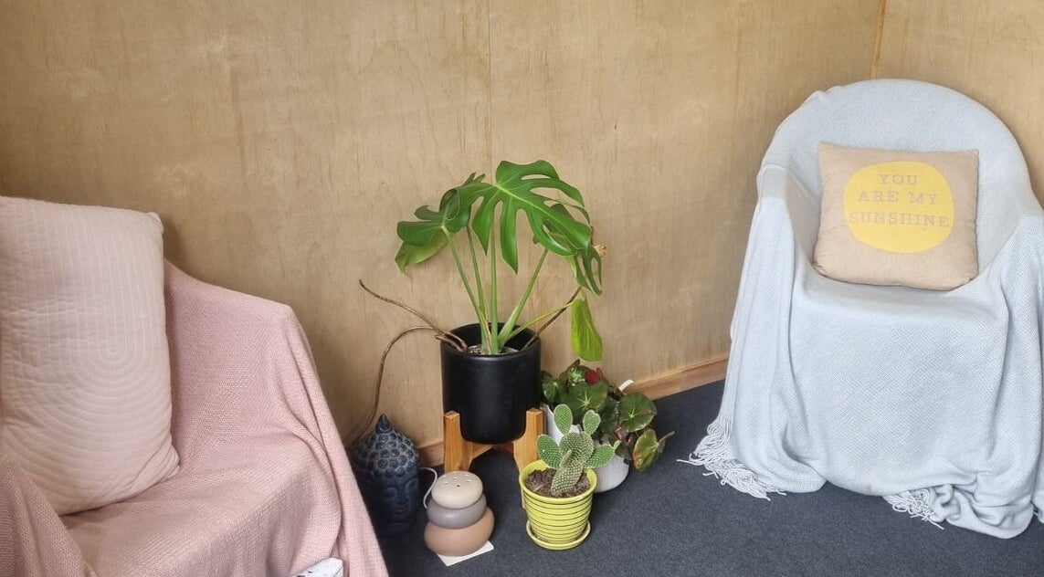 Relaxing corner with cozy chairs and plants at The Palms Studio, Waihi, Waikato, NZ.