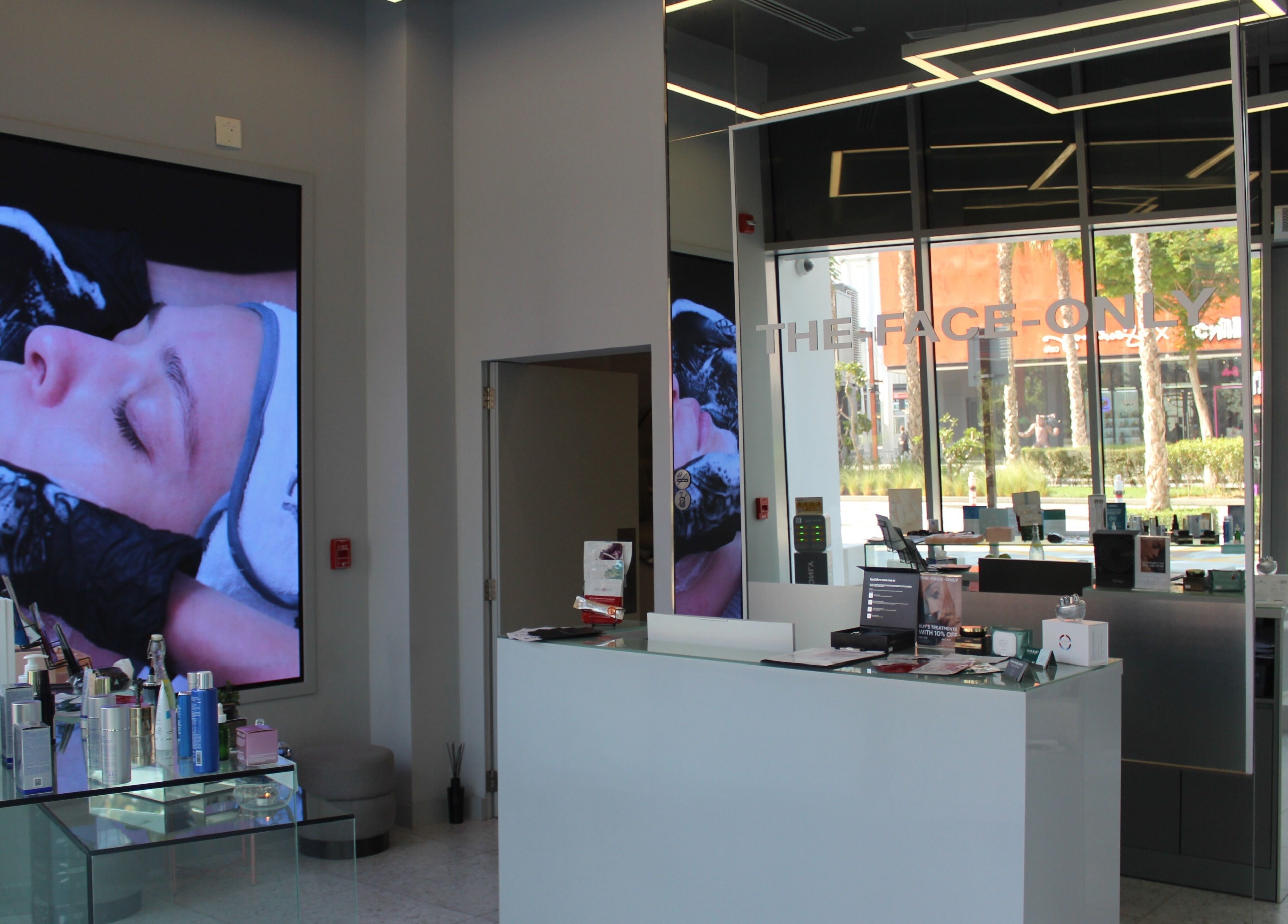 Interior view of The Face Only, Dubai, Dubai, AE showing a modern spa reception with skincare products.