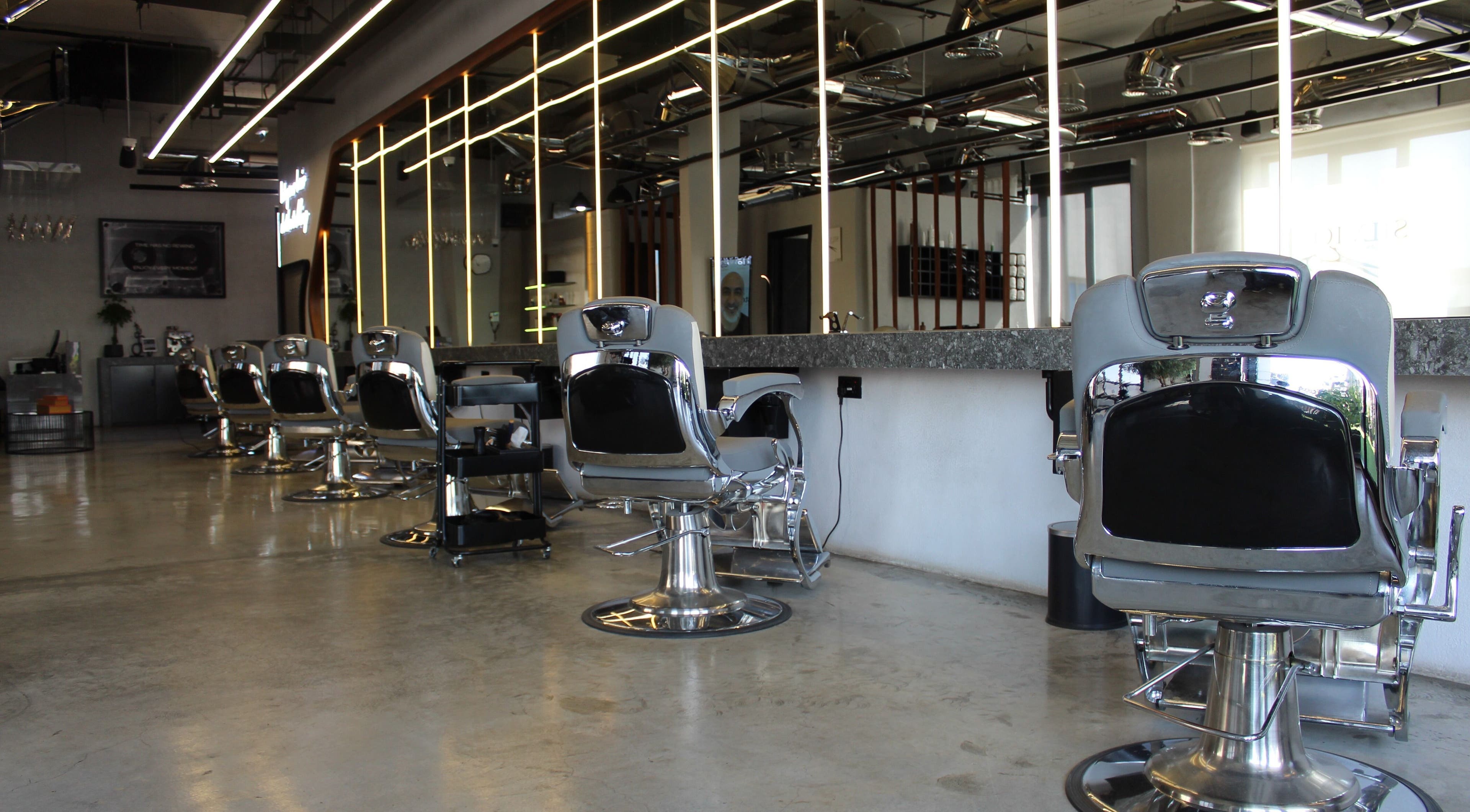 Modern interior of Silvio Alkassab Gents Salon in دبي, دبي, AE featuring sleek barber chairs.