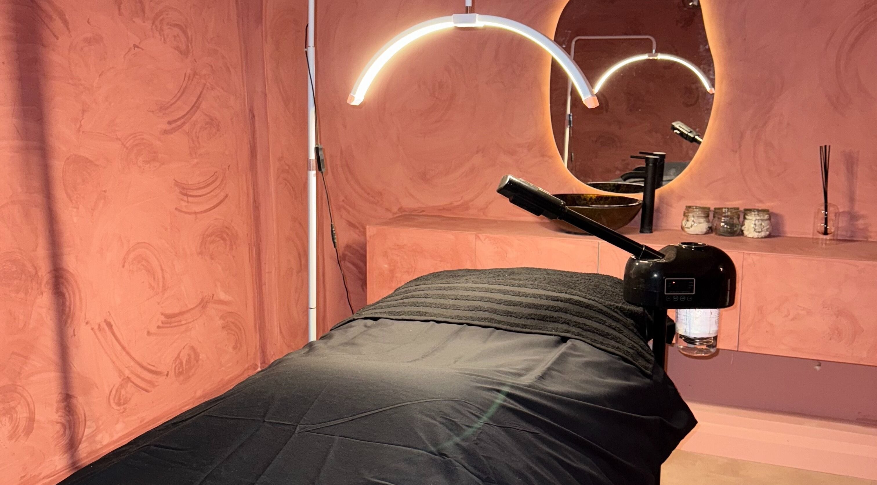 Tranquil treatment room at Beauty Hideout, Romford, England, GB with a softly lit spa bed and ambient decor.