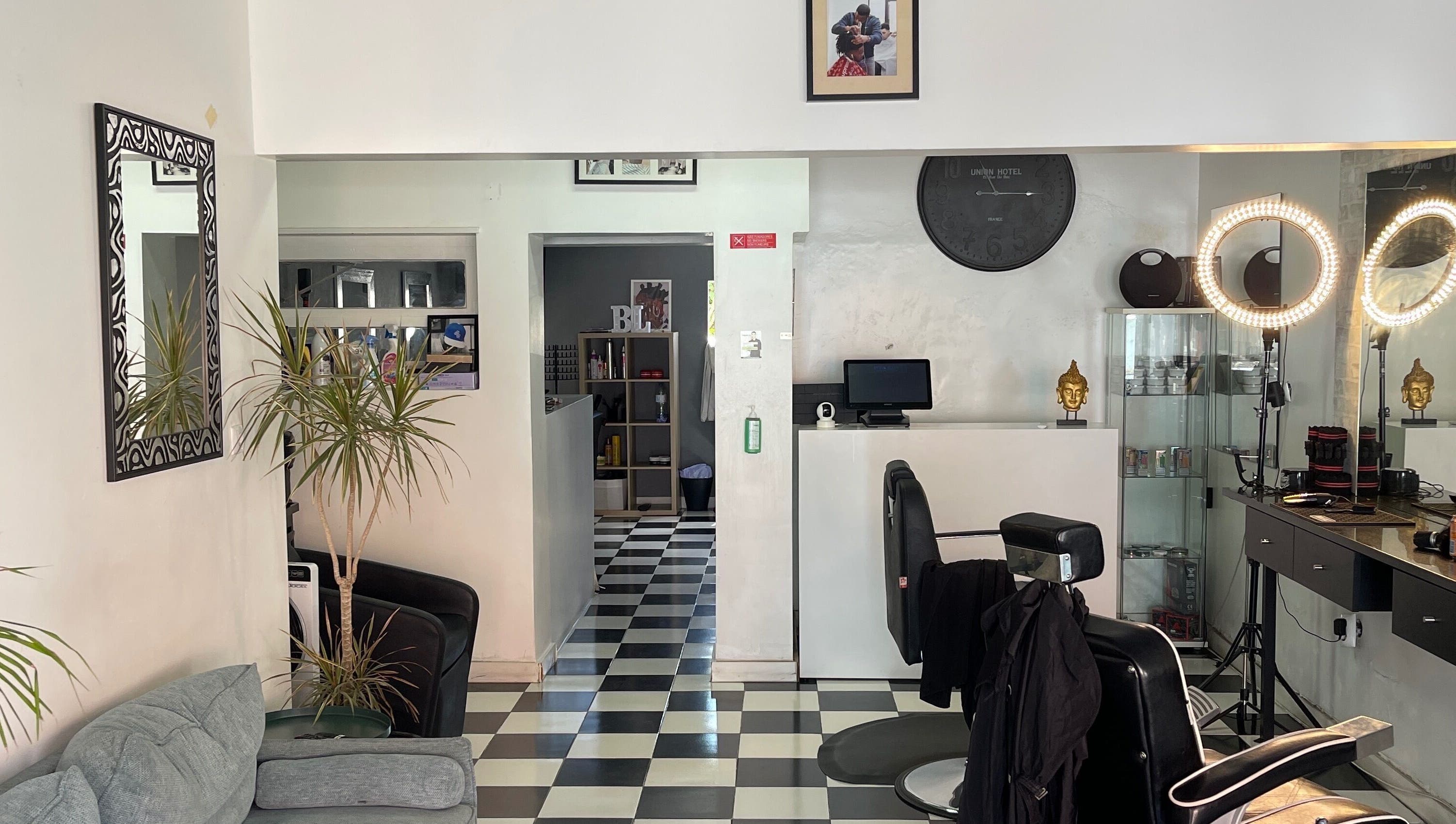 Interior moderno do Carlinhos Varela Barbeiros em Alcabideche, Lisboa, PT, com espelhos e decoração sofisticada.