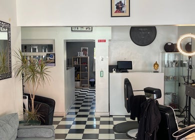 Interior moderno do Carlinhos Varela Barbeiros em Alcabideche, Lisboa, PT, com espelhos e decoração sofisticada.