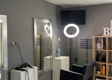 Interior moderno do Carlinhos Varela Barbeiros em Alcabideche, Lisboa, PT, com cadeira e espelho.
